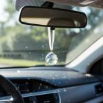 Clear Crystal Ball Prism the size of a nickle hanging from riew view car mirror.